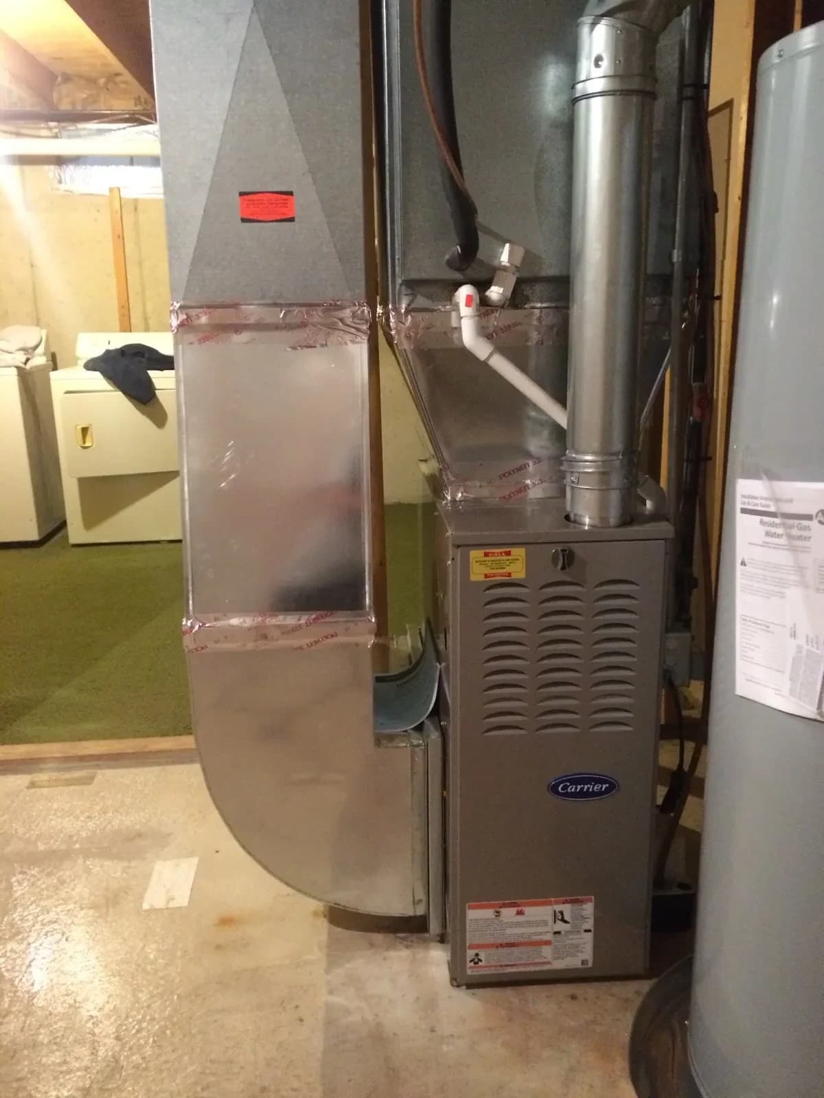 Mazure's technician repairing a Carrier furnace in a West Michigan home